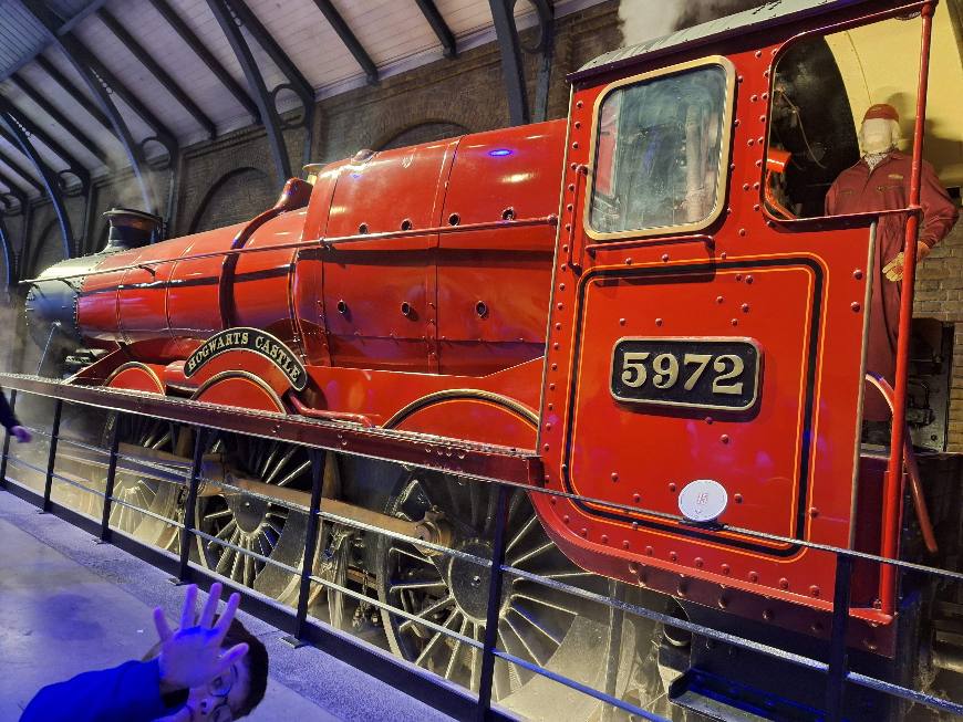 Le train Poudlard Express aux Studios Harry Potter de Londres avec un enfant de 5 ans devant la locomotive.
